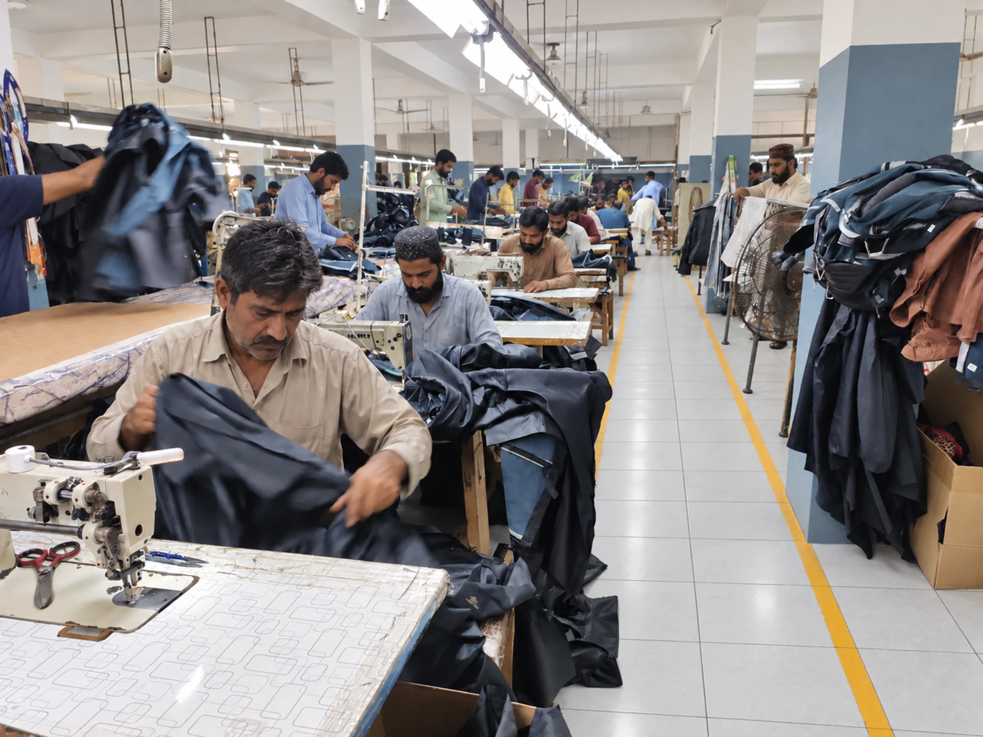 Skilled Pakistani leather craftsmen stitching garments